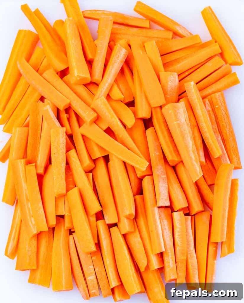 Parmesan Crusted Carrot Fries 5 Carrots meticulously cut into uniform strips, ready for seasoning.