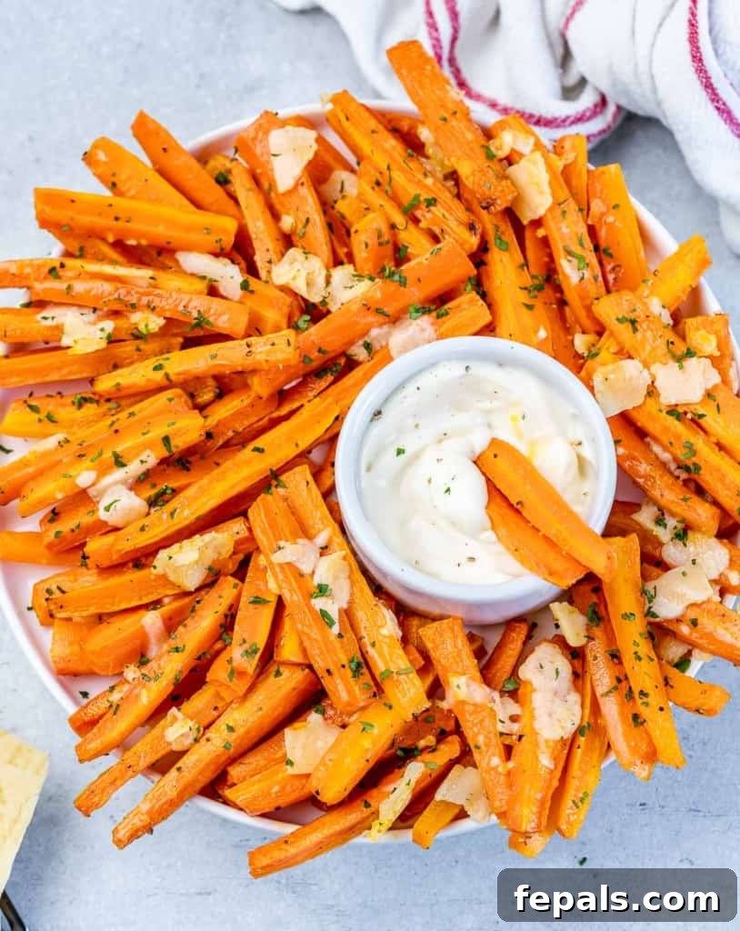 Parmesan Crusted Carrot Fries 9 Crispy roasted carrot fries served alongside a small bowl of dipping sauce, enticing and ready to eat.