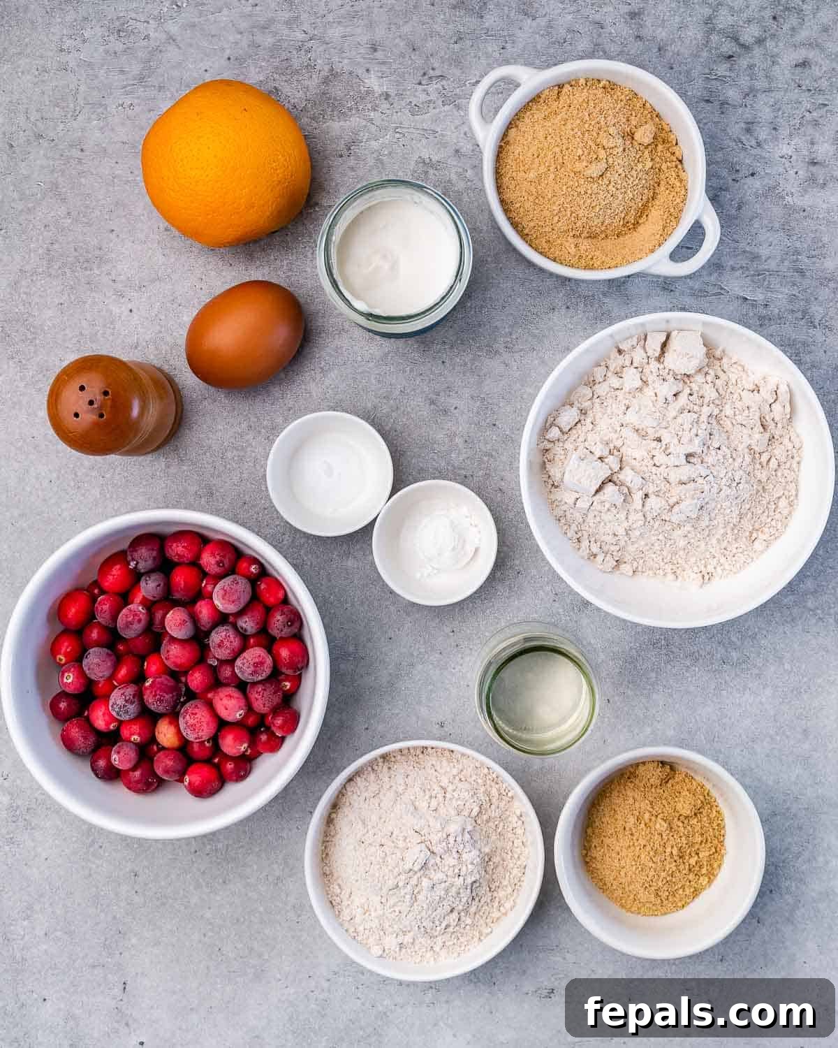 Wholesome Cranberry Orange Muffins 4 Flour, sugar, egg, yogurt and fresh cranberries divided into bowls.