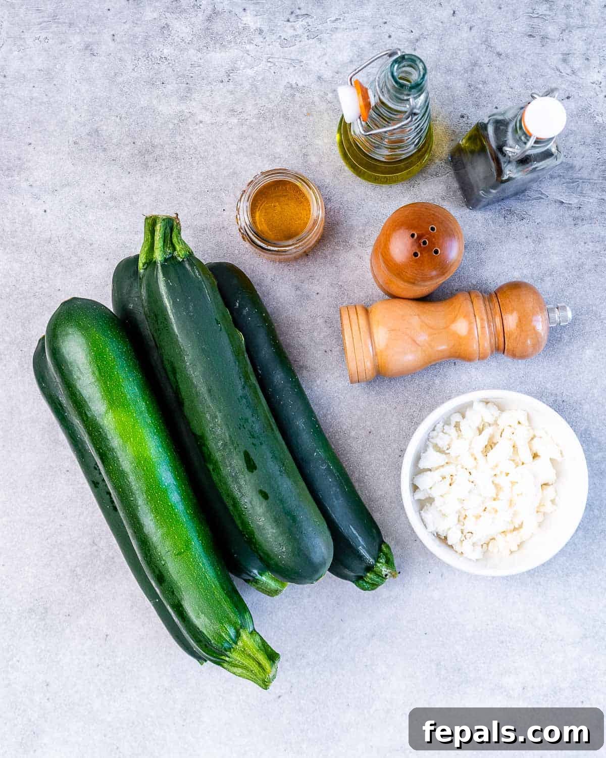 Raw zucchini with a bowl of goat cheese and spices.