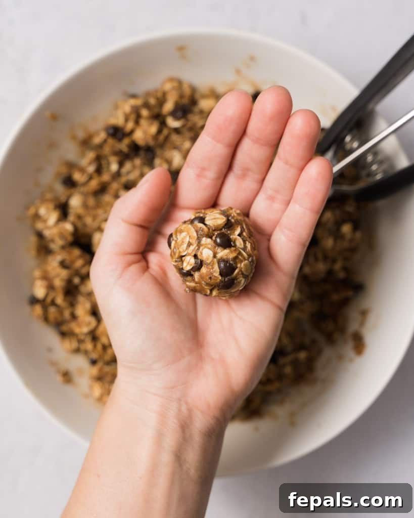 Spiced Pumpkin Power Morsels 13 Hands rolling the oatmeal dough into smooth, round energy balls.