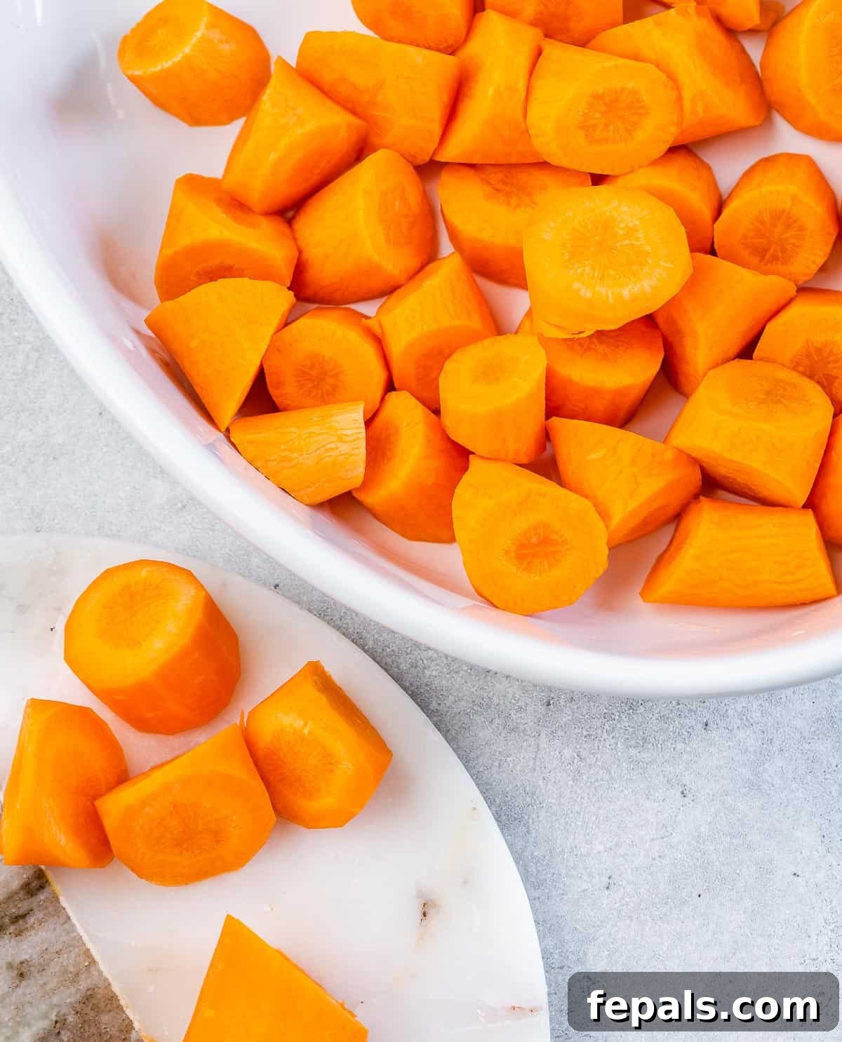 Maple-Kissed Roasted Whole Chicken 5 Chopped carrots in a baking dish, ready for roasting.