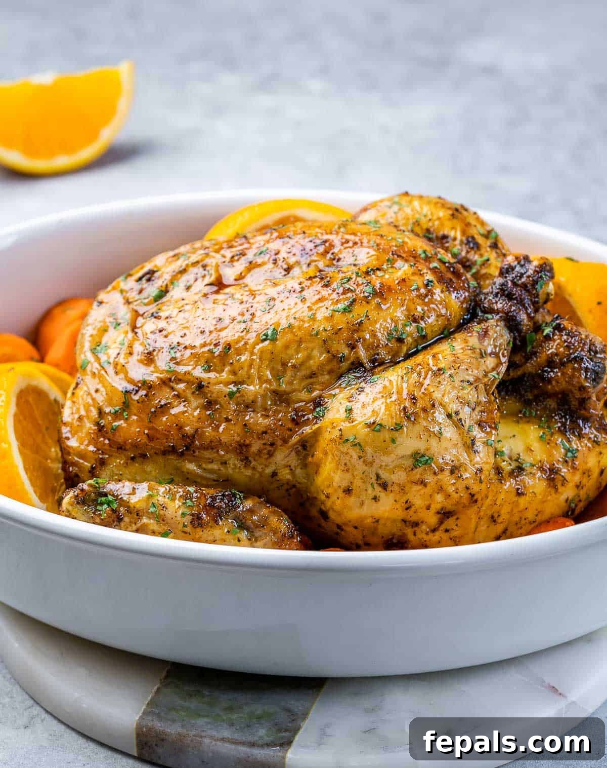 Maple-Kissed Roasted Whole Chicken 10 Baked whole chicken in a simple white casserole dish, emphasizing its rustic appeal.