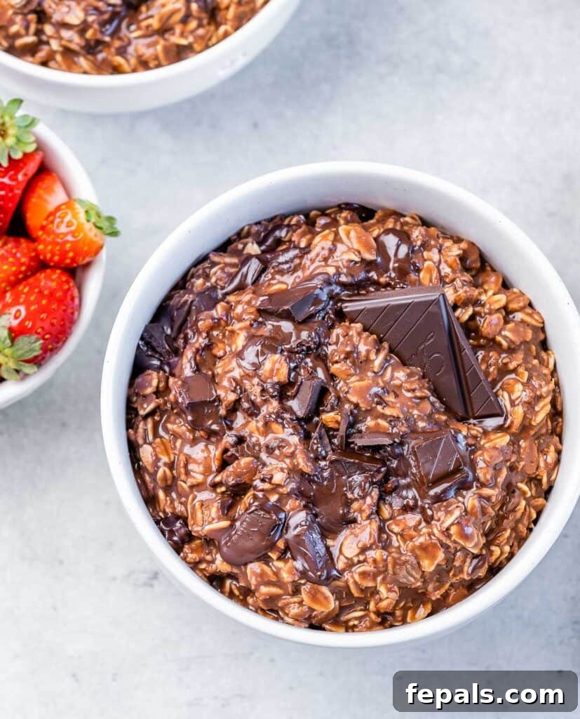 Decadent Cocoa Oat Delight 12 a white bowl with brown chocolate oatmeal topped with melted chocolate square bar
