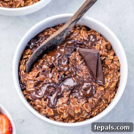 top view of a white bowl with chocolate cooked oatmeal topped with melted dark chocolate