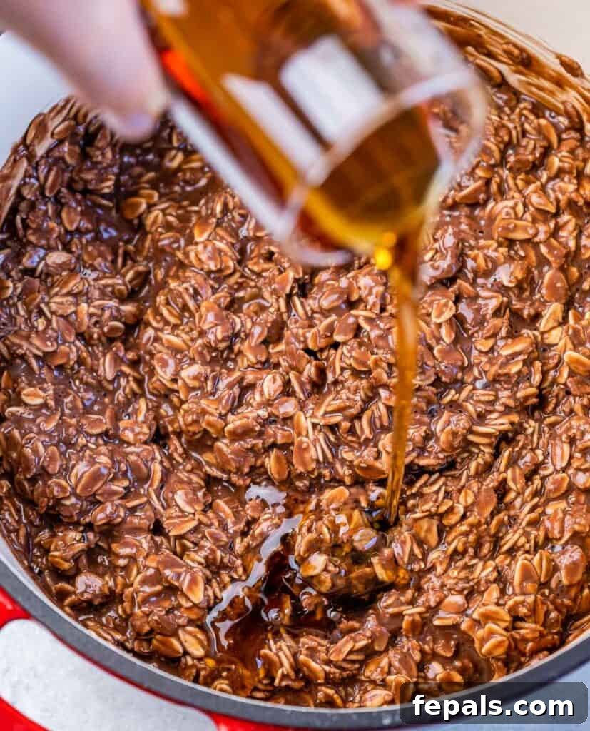 Decadent Cocoa Oat Delight 8 maple syrup being poured over cooked chocolate oatmeal in a pot