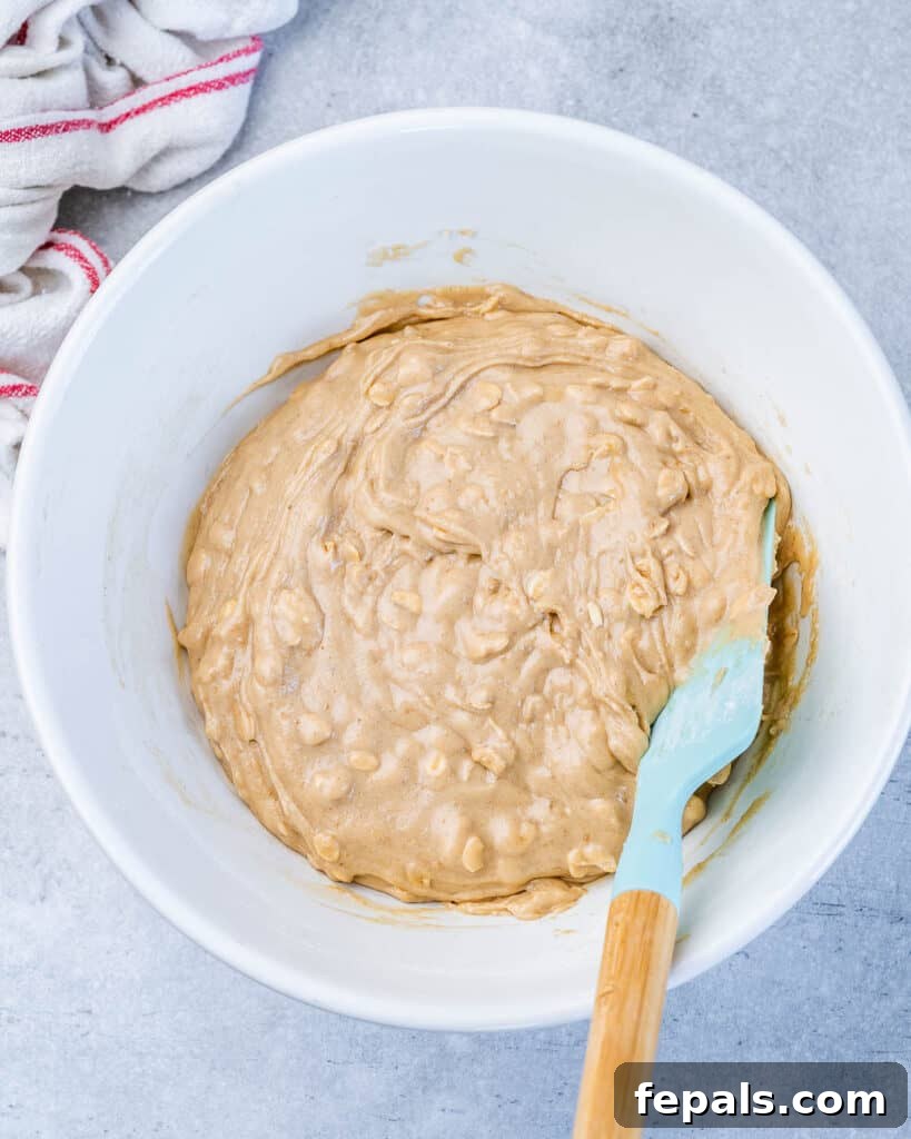 Stirring cookie dough in a white bowl.