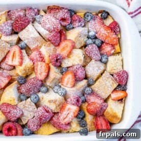 top view of a white dish with french toast casserole topped with fresh berries
