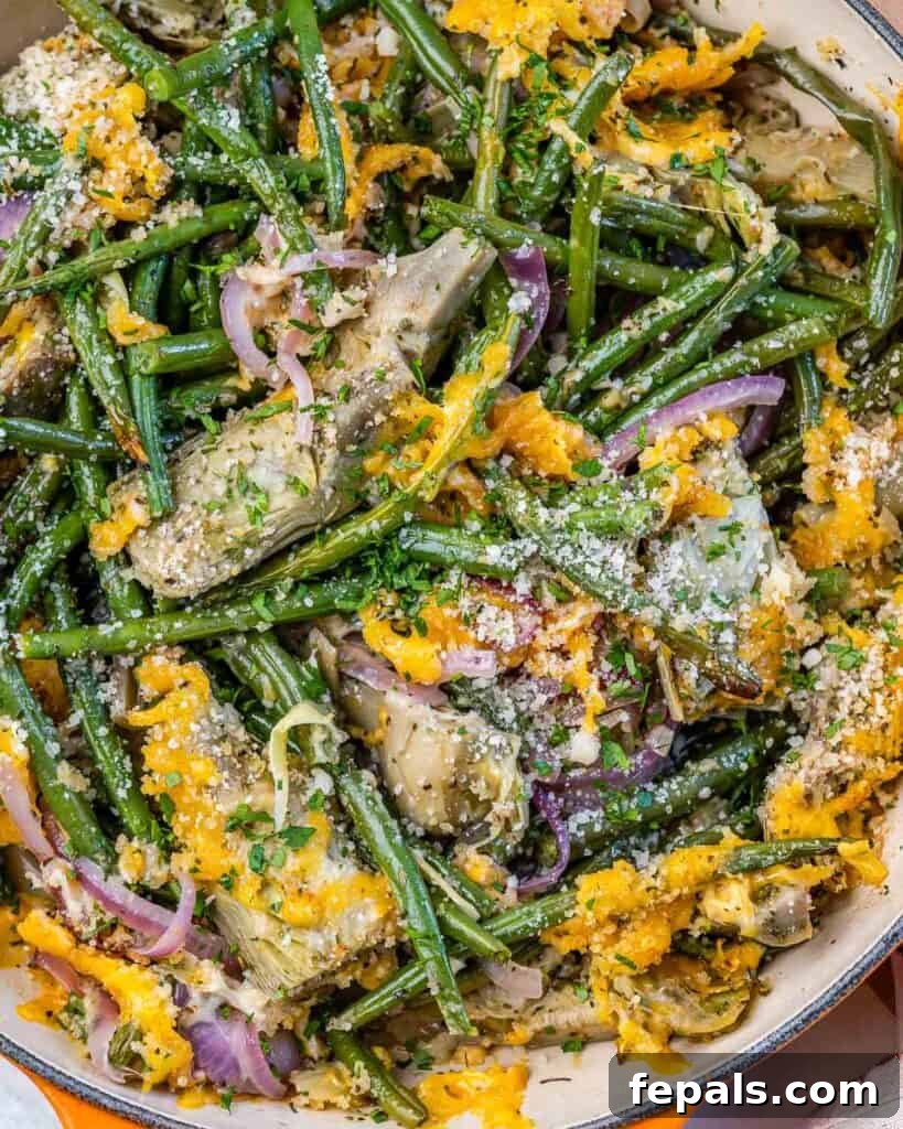 Mediterranean Artichoke Green Bean Bake 10 top close up view of artichoke casserole in an orange skillet with melted cheddar cheese