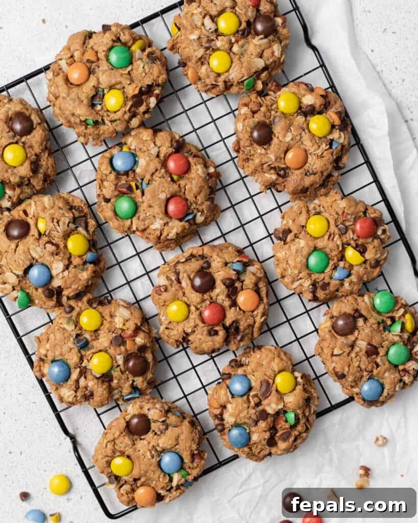 Baked monster cookies cooling on a wire rack, ready to be enjoyed.