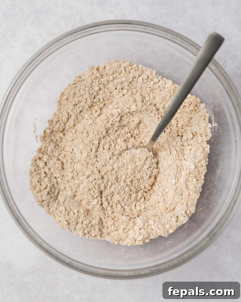 Wholesome Western Wonders 6 Stirring together flour with oats and cinnamon in a large bowl for cowboy cookies.