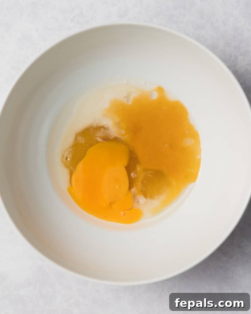 Wholesome Western Wonders 7 Adding eggs, vanilla and milk to a bowl for the wet ingredients of Healthy Cowboy Cookies.