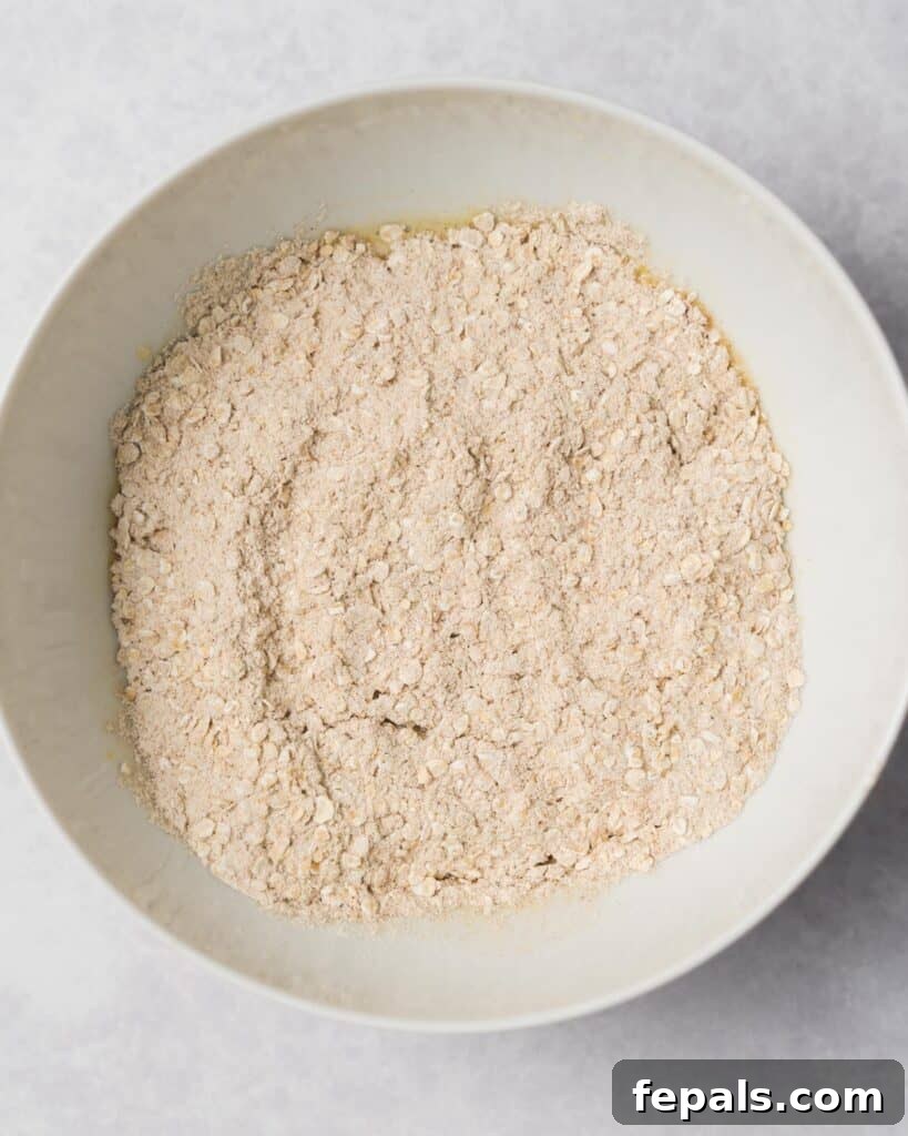 Wholesome Western Wonders 9 Adding flour mixture to egg mixture in a bowl for Healthy Cowboy Cookies dough.