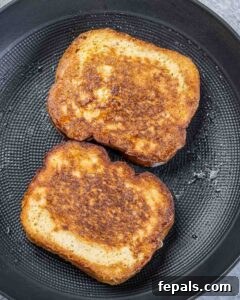 Peanut Butter Jelly French Toast Surprise 15 Cooking French toast in a pan.