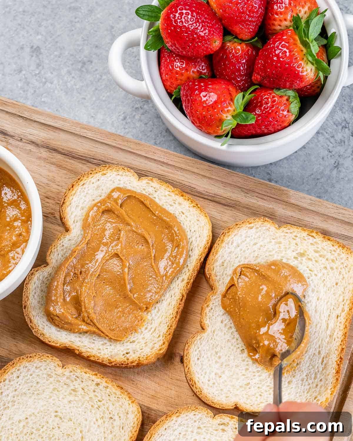 Peanut Butter Jelly French Toast Surprise 5 Spreading peanut butter on slices of bread.