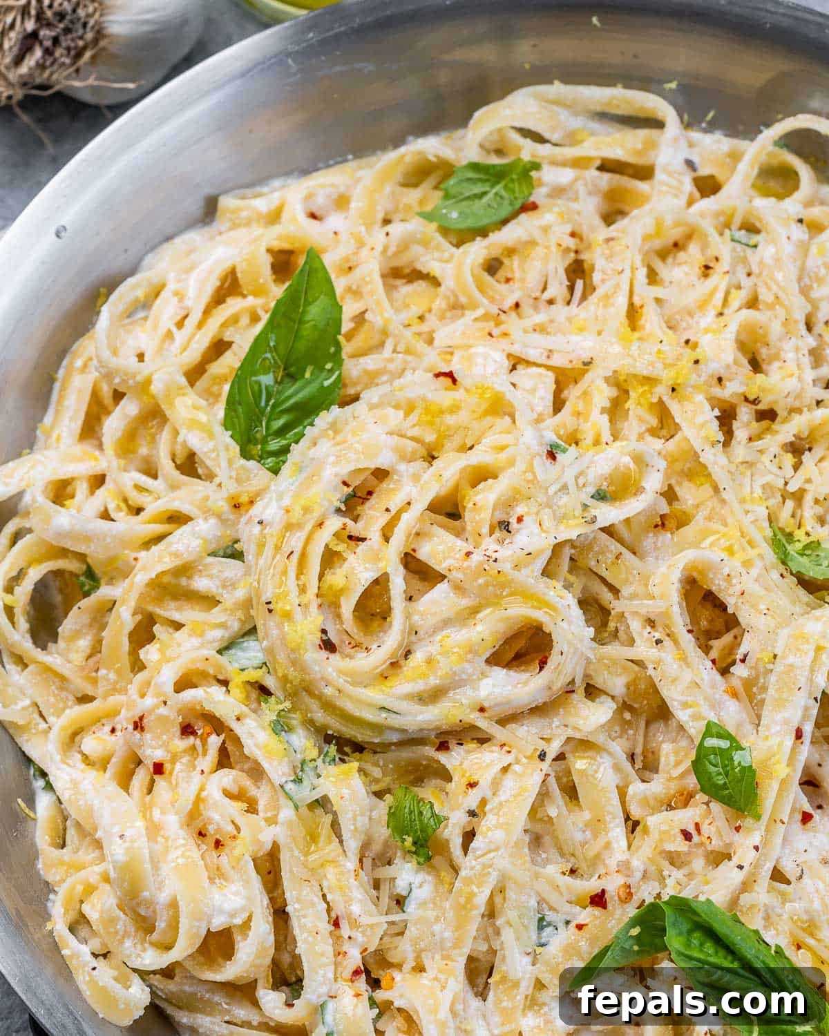 Bright Lemon Ricotta Pasta 10 Lemon Ricotta Pasta garnished with basil in a pan.