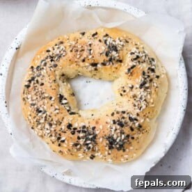 Protein-Packed Greek Bagels 13 top view of a single baked bagel topped with everything seasoning on a plate