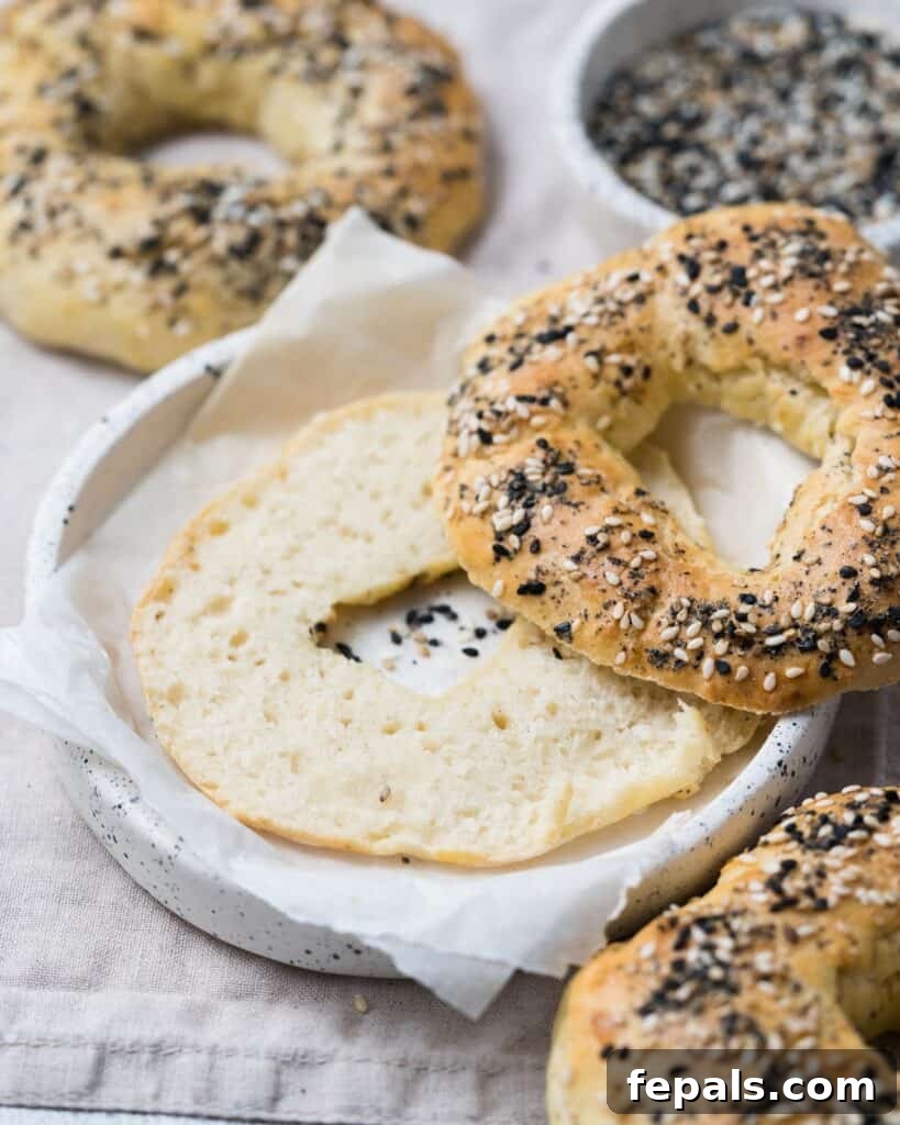 Protein-Packed Greek Bagels 3 sliced baked bagels on a plate with various toppings, ready to be enjoyed