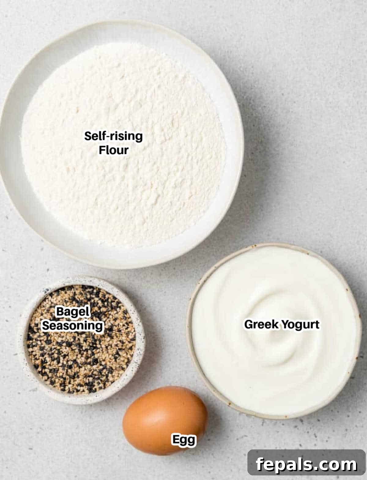 Protein-Packed Greek Bagels 4 a flat lay of ingredients to make Greek Yogurt bagels, including flour, yogurt, and optional toppings