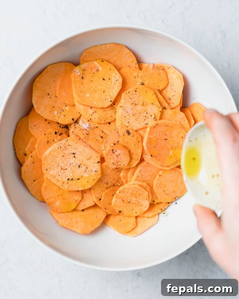 Crispy Air-Fried Sweet Potato Crisps 7 sweet potato slices in a bowl being seasoned with oil, salt, and pepper