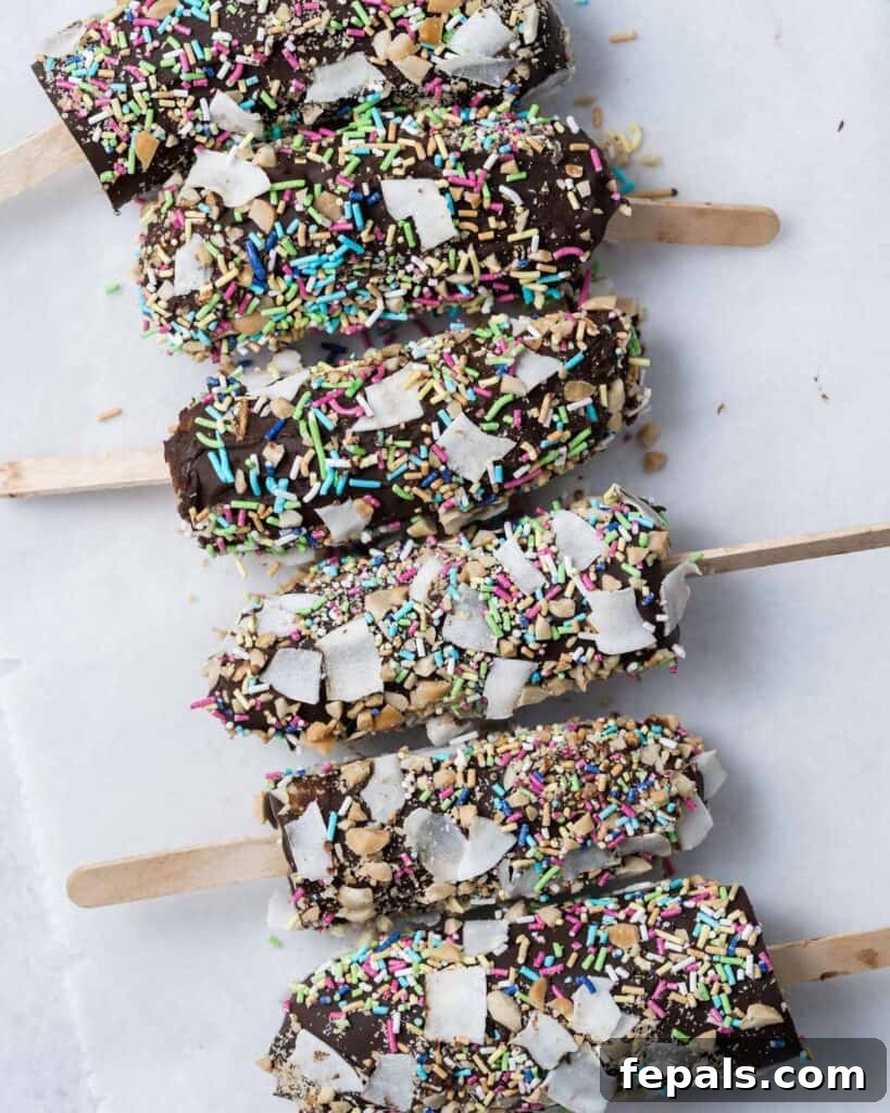Frozen Chocolate Banana Bites 3 6 banana pops covered in sprinkles laid out on a flat surface