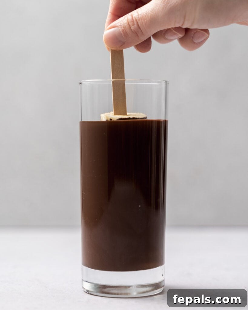 Frozen Chocolate Banana Bites 10 hand dipping banana pop in melted chocolate