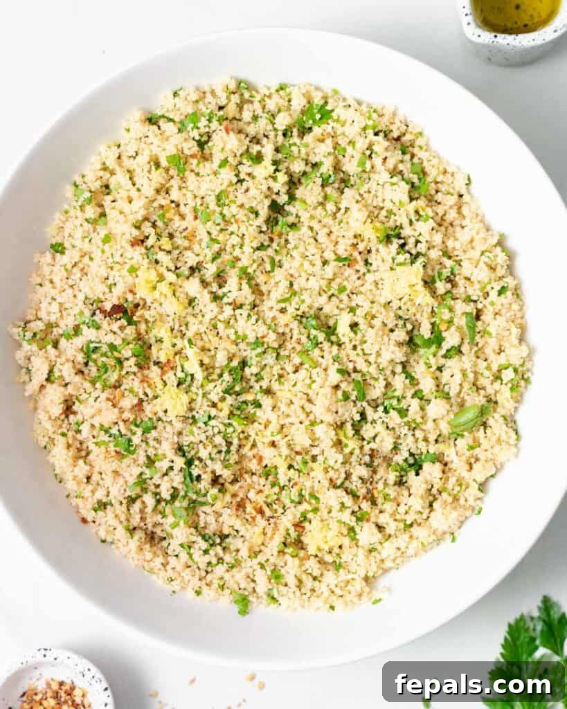Couscous in a white bowl with the addition of parsley.