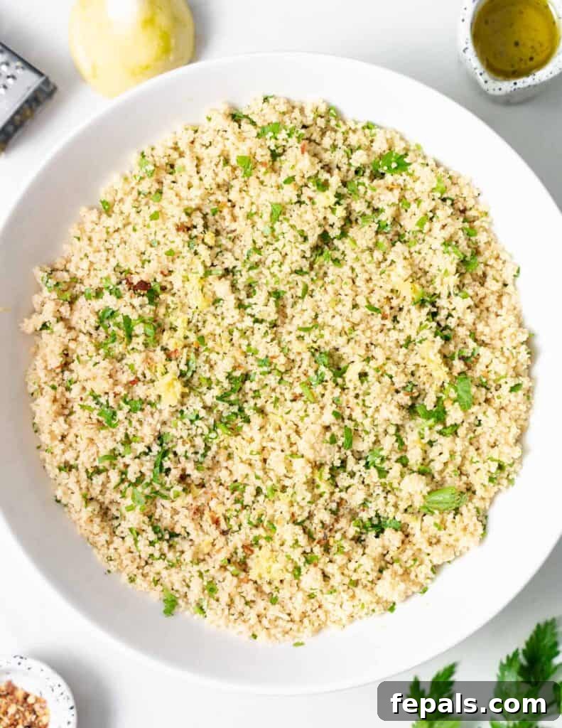 top view of round white plate with cooked couscous topped with fresh parsley