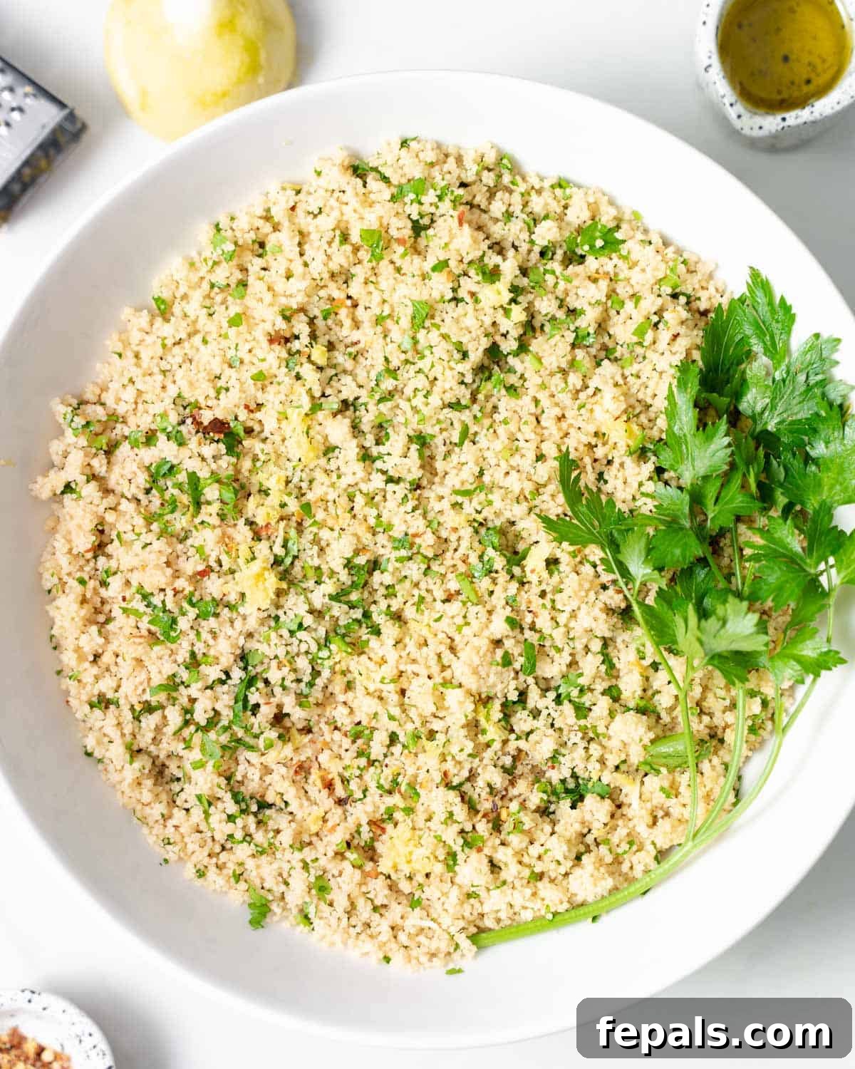 Couscous served in a white bowl garnished with fresh parsley.