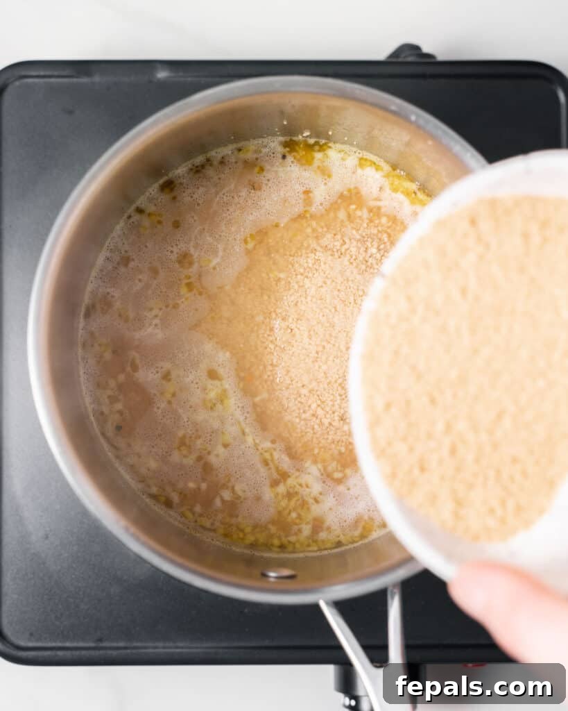Adding couscous into boiling water in a pot.