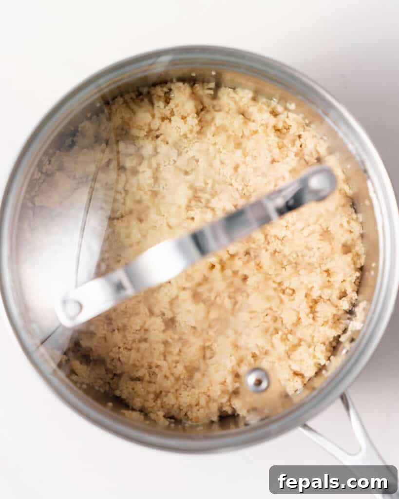 Couscous absorbing water in a covered pot.