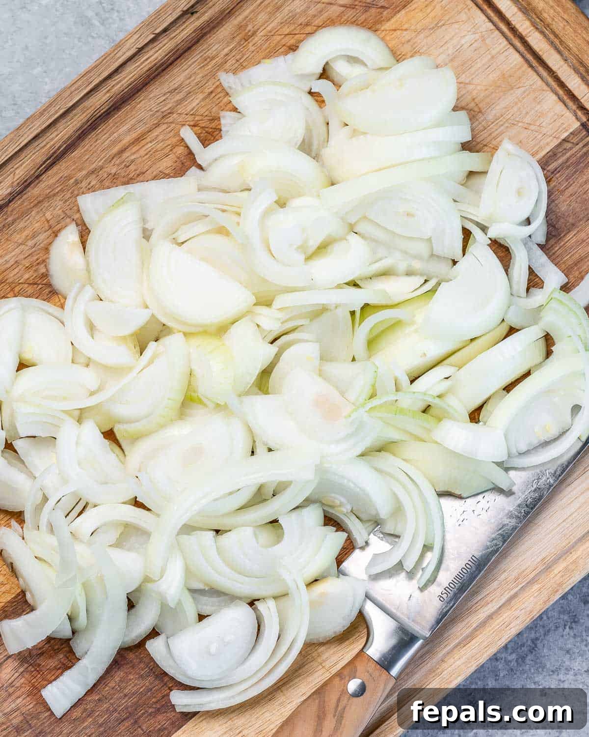 Effortless French Onion Elegance 5 Chopped onion on a cutting board.