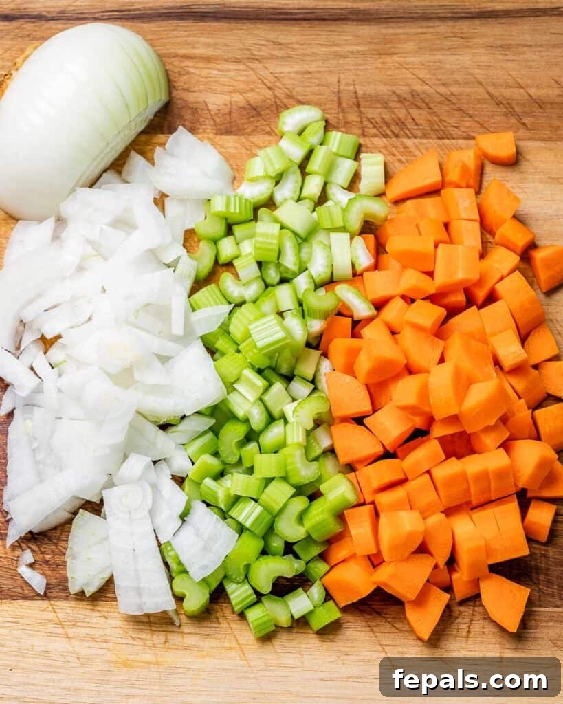 Hearty Beef Noodle Comfort 5 Onion, celery and carrots chopped on a cutting board.