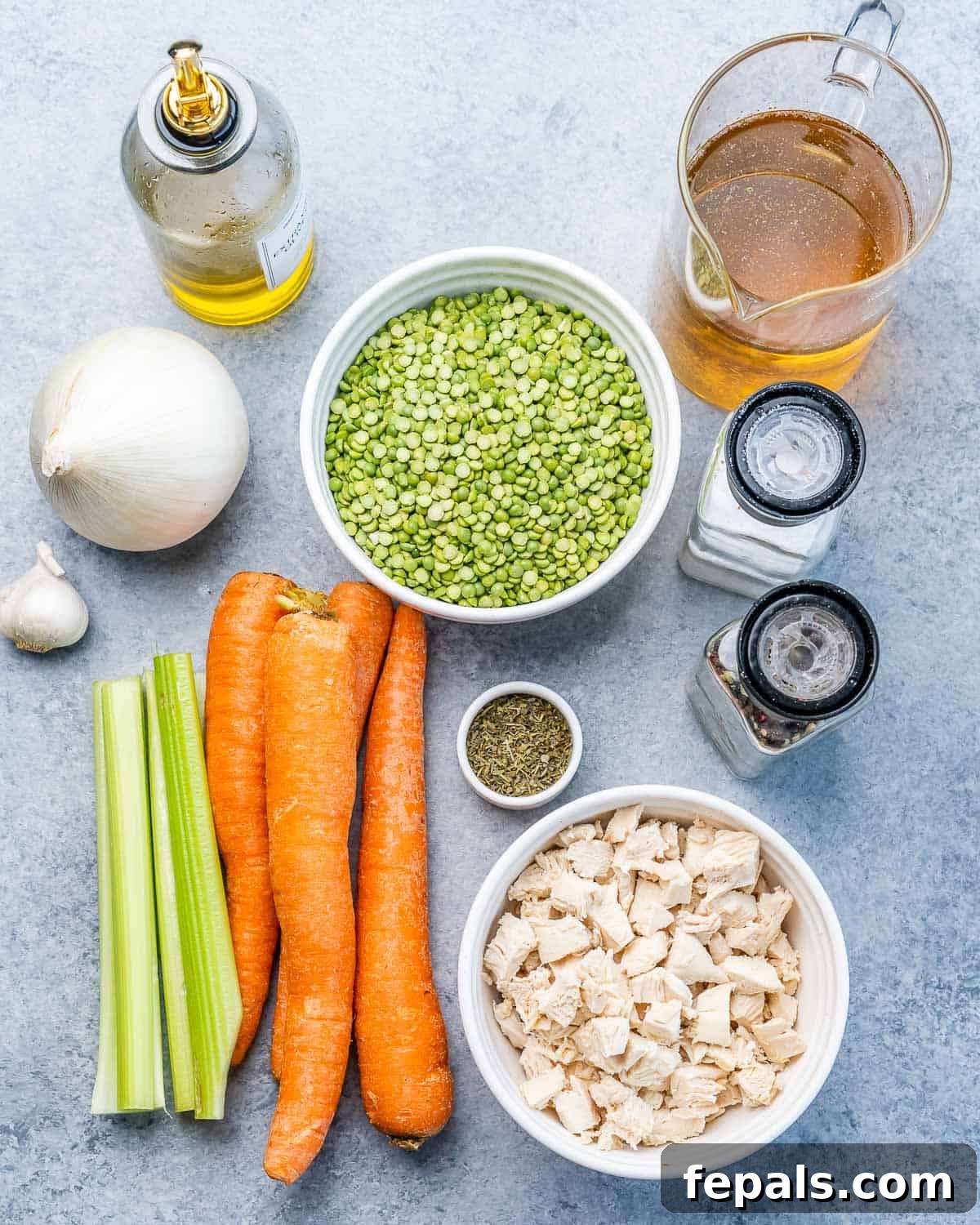 Individual ingredients for slow cooker split pea soup: dried peas, diced carrots, celery, chopped cooked chicken, and a measuring cup of broth.
