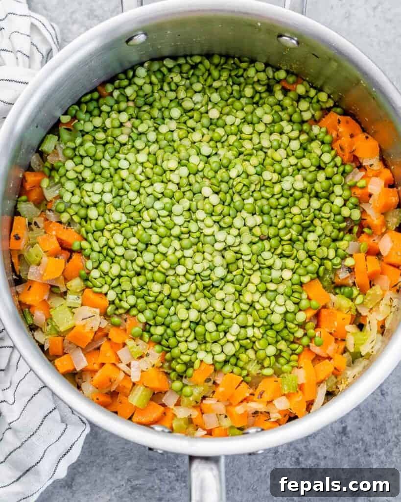 Adding dried split peas to the sautéed vegetables in a pot.