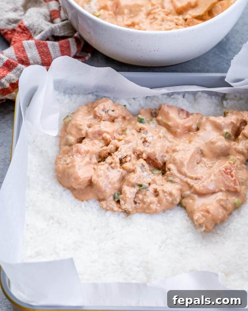 Ultimate Salmon Sushi Bake 7 Assembling a sushi casserole with rice and salmon mixture.