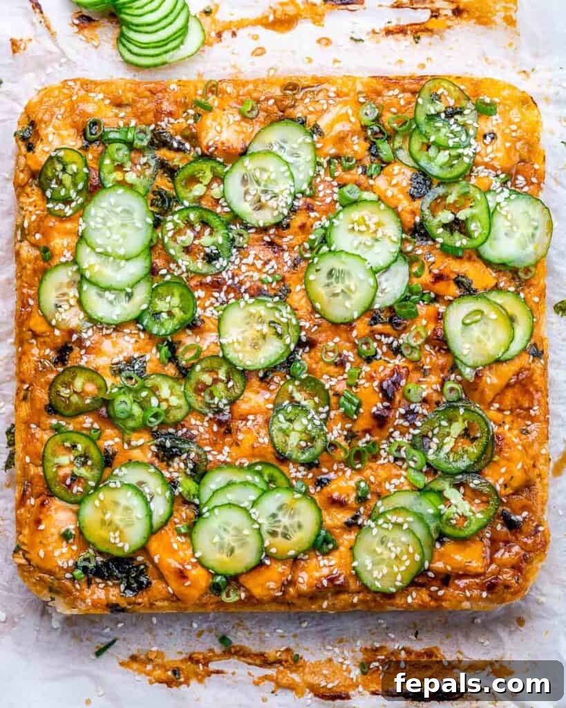 Ultimate Salmon Sushi Bake 9 Baked salmon sushi bake topped with sauce and cucumber and jalapeños.