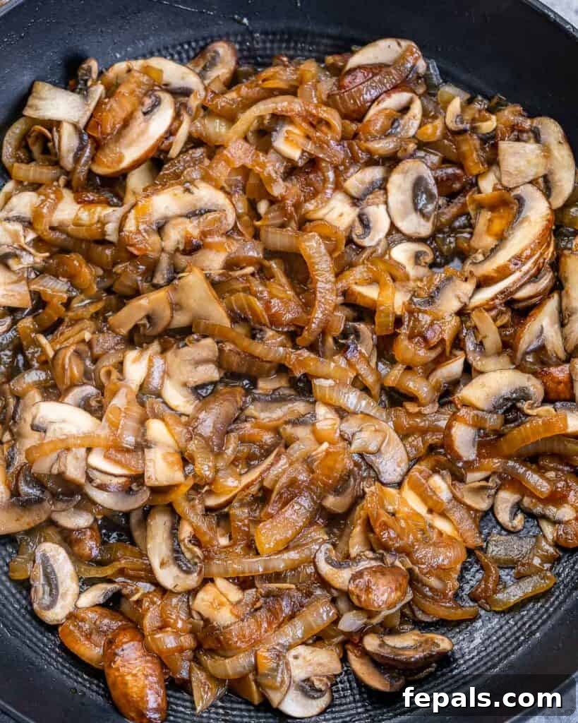 Caramelized Onion and Gruyere Pasta 7 Adding sautéed mushrooms and garlic to caramelized onions in a skillet.