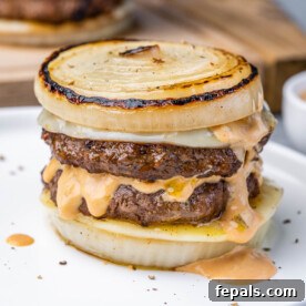 The Spectral Sailor Burger 12 side shot of a dutchman burger which is bunless with sliced onions as buns and melted cheese with in and out sauce