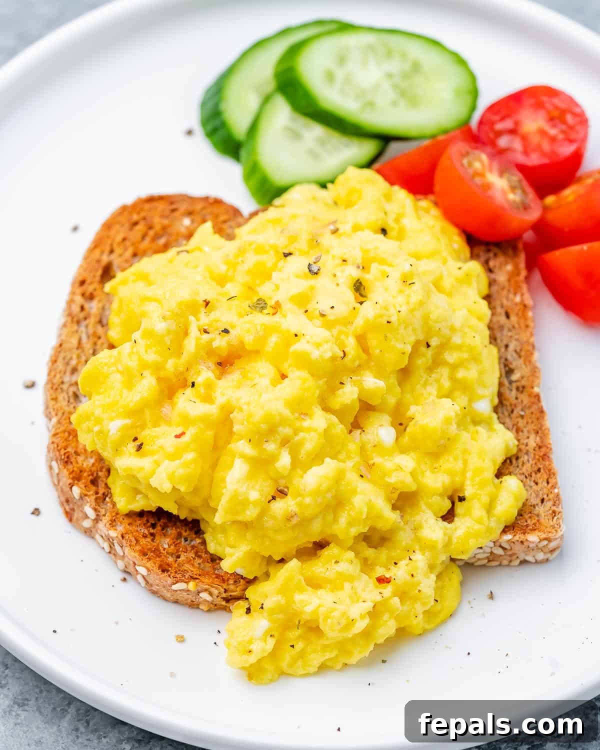 Creamy Protein Scramble 3 Cottage cheese eggs served on toast with a side of fresh veggies.