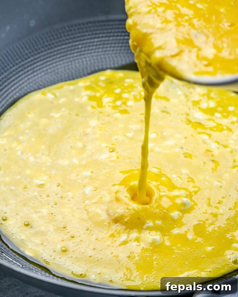 Creamy Protein Scramble 6 Pouring eggs into a skillet.