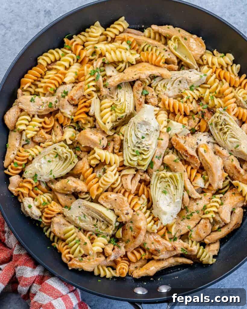 Creamy Chicken Artichoke Delight 2 top view of black skillet with pasta chicken and artichoke