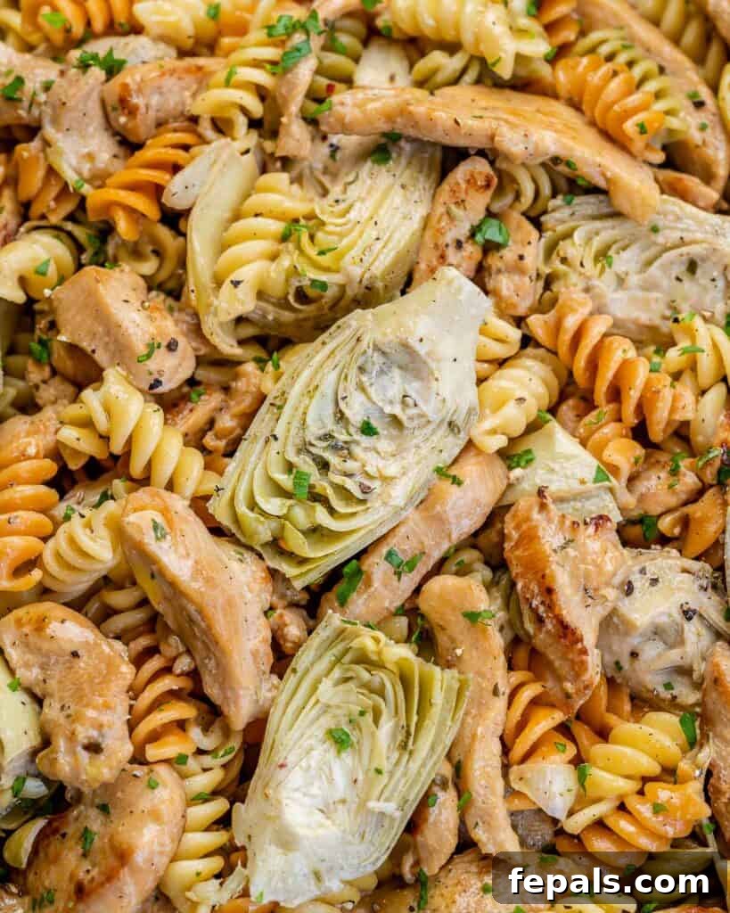 Creamy Chicken Artichoke Delight 11 close image of pasta with artichokes and chicken in a pan