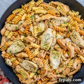 Creamy Chicken Artichoke Delight 12 skillet with pasta and chicken with artichoke.