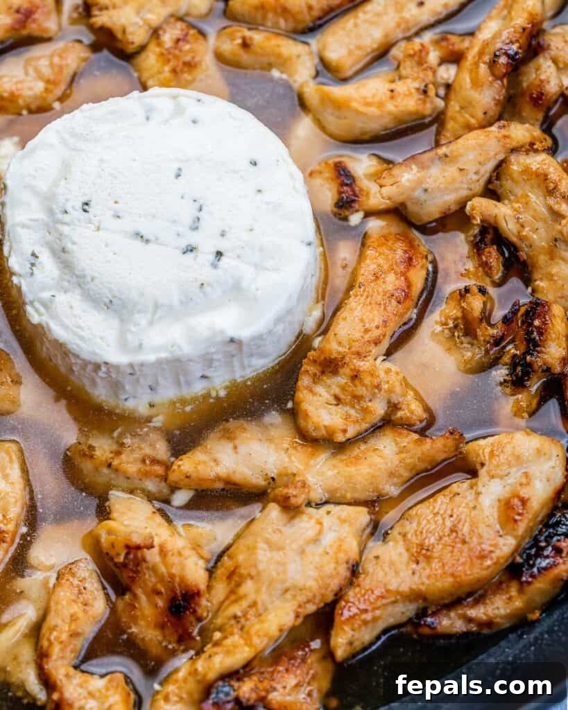 Creamy Chicken Artichoke Delight 6 boursin cheese with cooked sliced chicken on a skillet before mixing