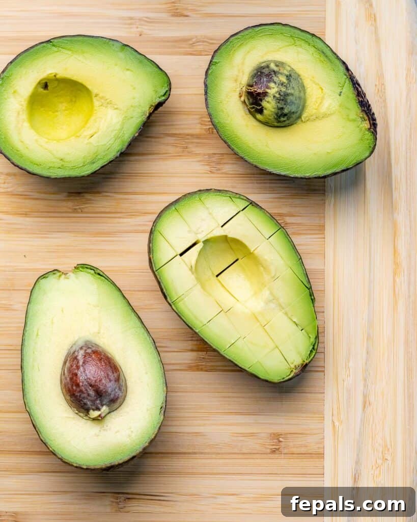 4 sliced avocados on a wooden board