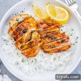 top view of a round white bowl with steamed white rice and sliced air-fried boneless chicken thighs