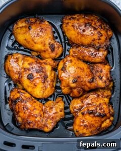 Air fryer boneless chicken thighs cooking.