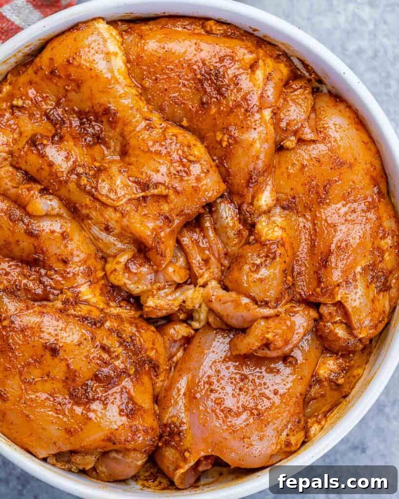 Crispy Air Fryer Boneless Chicken Thighs 6 Chicken thighs marinating in a white bowl.