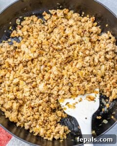 Browning ground chicken in a skillet.